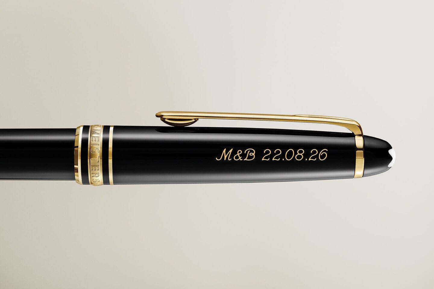Personalised Montblanc Meisterst&uuml;ck fountain pen in black precious resin with gold-coated clip and rings, featuring the iconic snowcap emblem, in a detailed close-up.