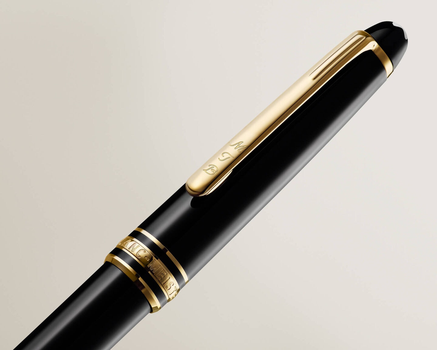 Personalised Montblanc Meisterst&uuml;ck fountain pen in black precious resin with gold-coated clip and rings, featuring the iconic snowcap emblem, in a detailed close-up.